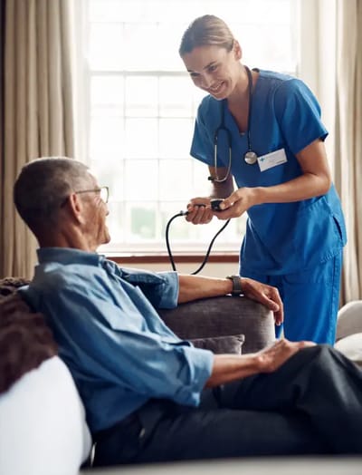 A nurse checks a patient's blood pressure.