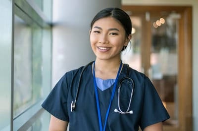 Nurse smiling in a facility interior.