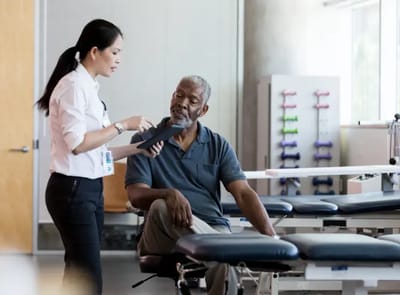 Staff assisting a resident in a rehabilitation setting.