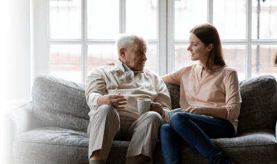 A senior man and woman share a caring conversation.