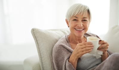 Smiling older woman enjoying a warm drink
