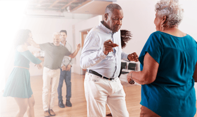 Residents enjoying a dance activity in a common area.