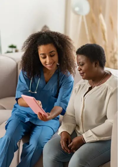 Caregiver assisting a resident with a tablet.