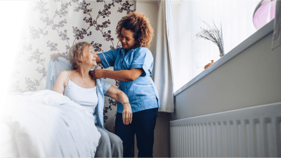 Caregiver assisting a resident in their room