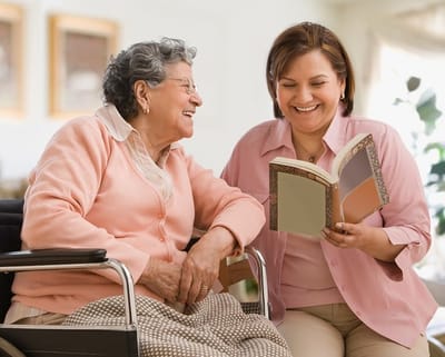 A senior resident and staff member reading together