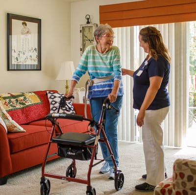 Staff assisting a resident in a cozy living room