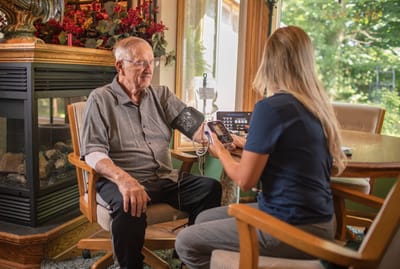 Staff member checking the blood pressure of a resident