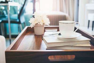 A cozy living space with a tray of tea and flowers