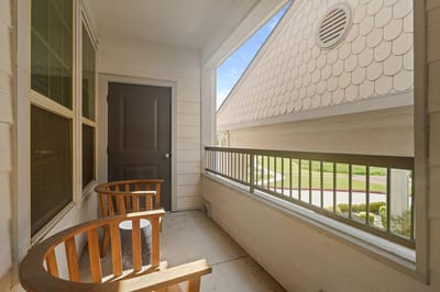 Bright balcony with wooden chairs and view of exterior