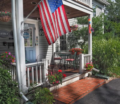 Welcoming porch with flowers and American flag