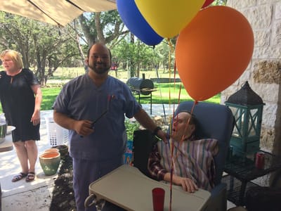 Staff member celebrating with resident outdoors