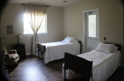 A shared resident room with two beds and natural light