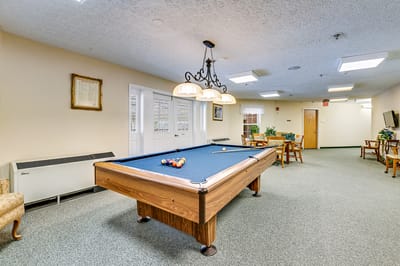 A bright common area with a pool table and seating