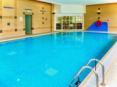 Indoor swimming pool area with bright lighting