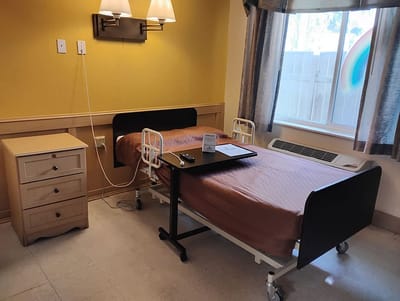 A resident room with adjustable bed and nightstand