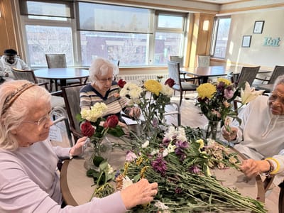 Residents creating flower arrangements in a common area
