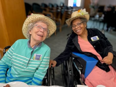 Two residents enjoying a celebration with hats.
