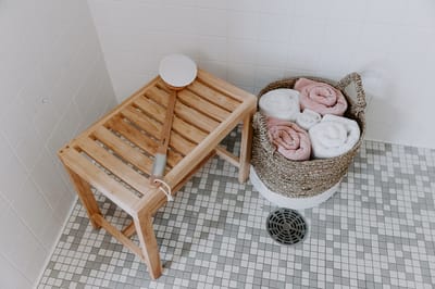 Spa shower area with a wooden bench and towels