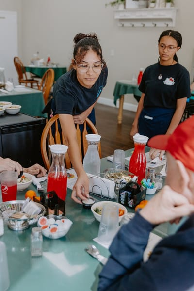 Staff serving food to residents in a dining area