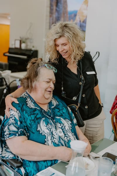 A caregiver assisting a resident in a dining area