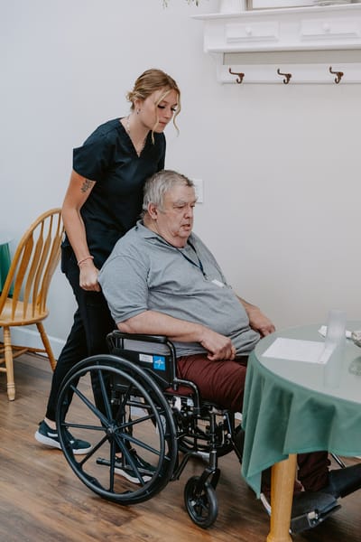 Caregiver assisting a resident in a wheelchair