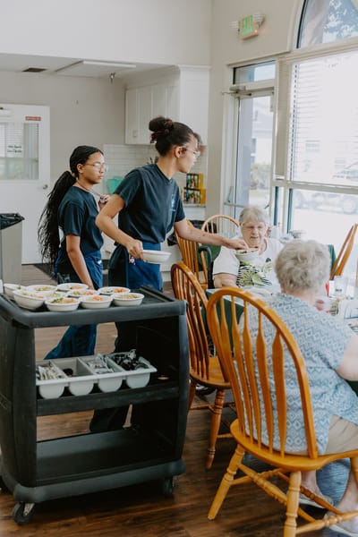Staff serving food to residents in the dining room