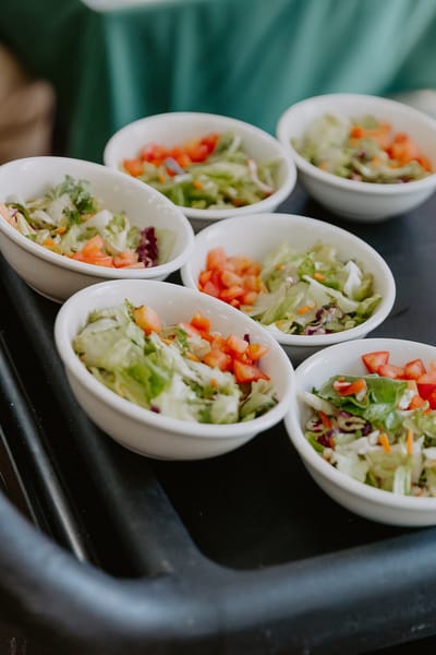 Bowls of fresh salad served on a tray