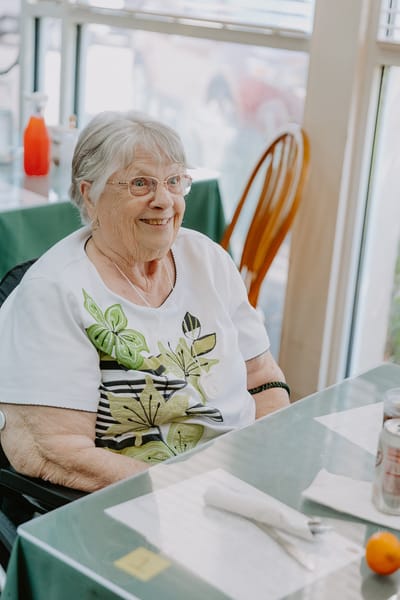 A smiling resident sitting at a table