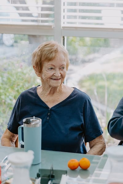 Elderly woman smiling in a bright common area