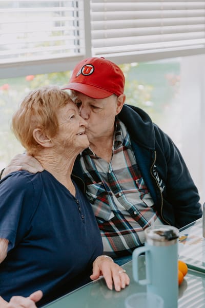 A resident and staff member engaging warmly at a table