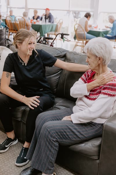 Staff interacting with a resident in a cozy common area