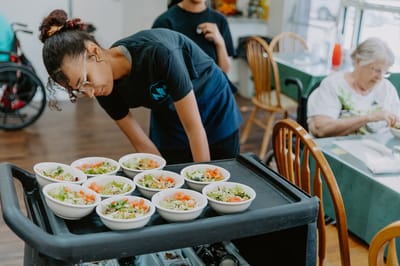 Staff serving meals to residents in the dining area