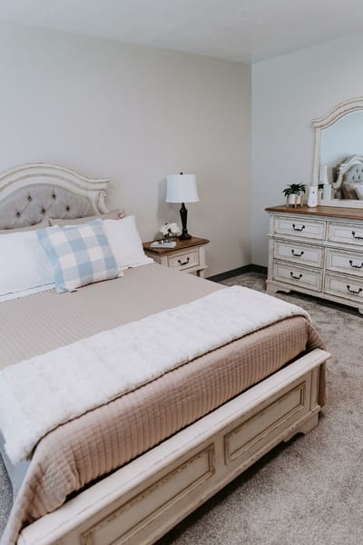 Cozy bedroom with a beige bedspread and mirror