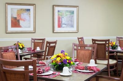Dining area set up with colorful flower arrangements