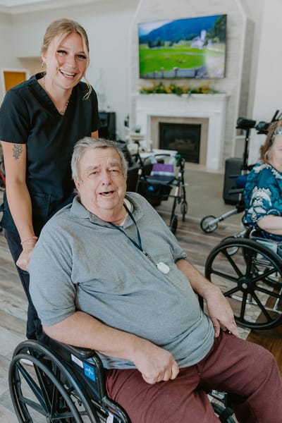 Resident smiling in a common area with staff member
