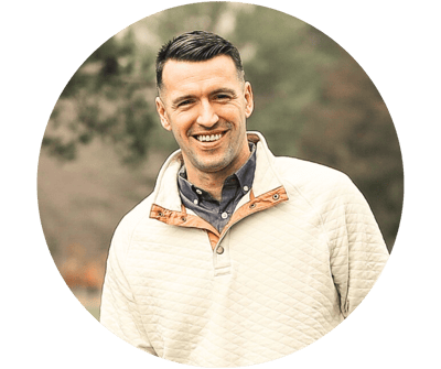 A smiling man in a casual sweater outdoors