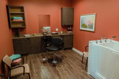 Interior of a salon space with seating and a tub.