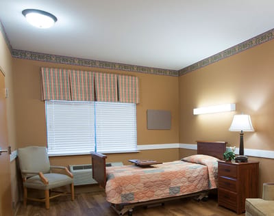 Well-furnished resident room with bed and chair