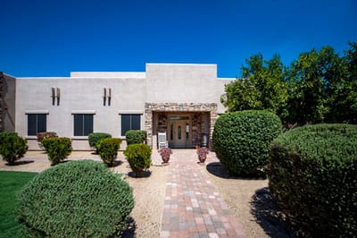 Front entrance of a senior living facility with landscaped gardens
