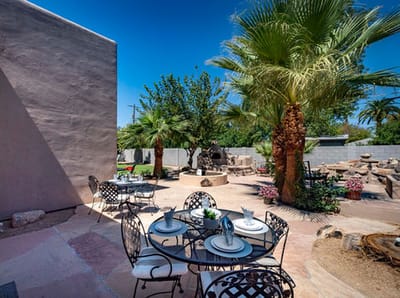 Outdoor dining area with tables and palm trees