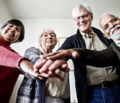 Avamere Rehabilitation of Lebanon, Nursing Home in Lebanon, OR — Seniors smiling and placing hands together in a circle