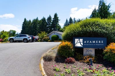 Facility entrance showing landscaping and vehicles