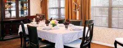 Well-set dining room with a large table and flowers