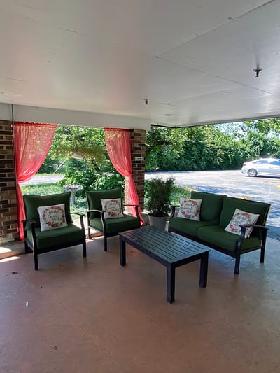Outdoor seating area with green chairs and cushions