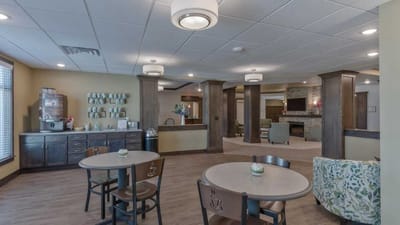 Cedar Ridge Village, nursing home in West Des Moines, IA — Common area with tables, chairs, and decorative elements