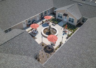 Benton House of Decatur, assisted living in Decatur, GA — Courtyard with fountain and seating areas under umbrellas