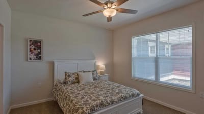 Cedar Ridge Village, nursing home in West Des Moines, IA — Cozy bedroom with a large window and ceiling fan