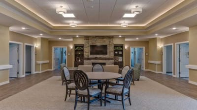 Cedar Ridge Village, nursing home in West Des Moines, IA — Spacious activity room with circular table and stone fireplace