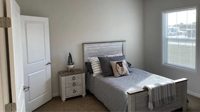Cedar Ridge Village, nursing home in West Des Moines, IA — Cozy bedroom with a bed and natural light