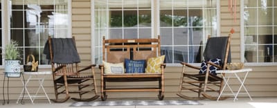 Rocking chairs on a porch with decorative pillows